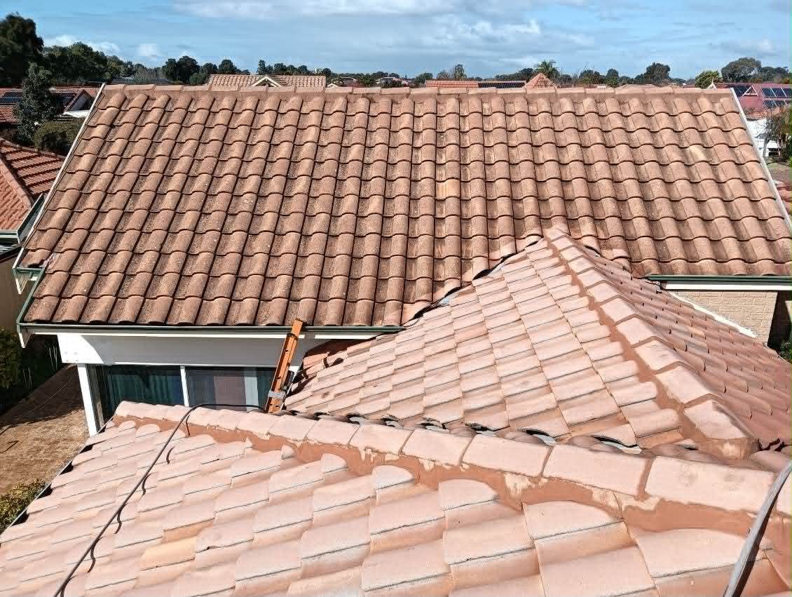 Faded terracotta tile roof with crumbling ridge capping, before restoration