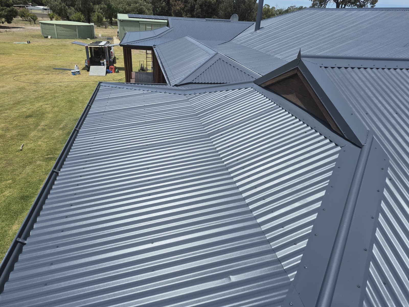 After: the roof sheets and ridge capping restored to a clean, even finish