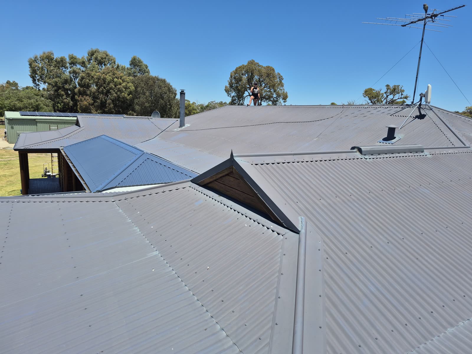 Before: worn metal sheets and ridge capping, faded and dull
