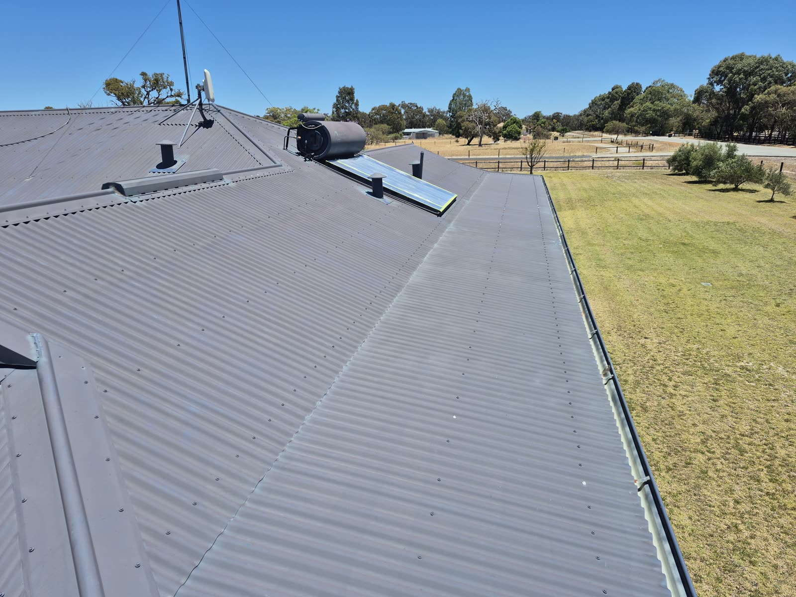 Before: the metal roof faded and chalky, the original coating worn back