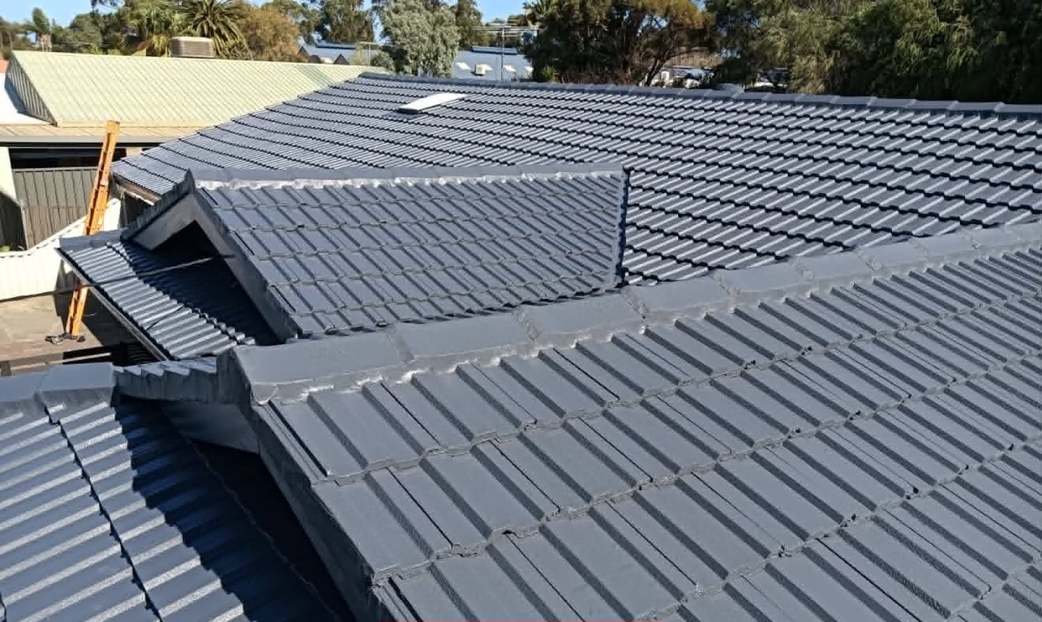 After: the tile roof cleaned and coated in charcoal, an even finish across every tile