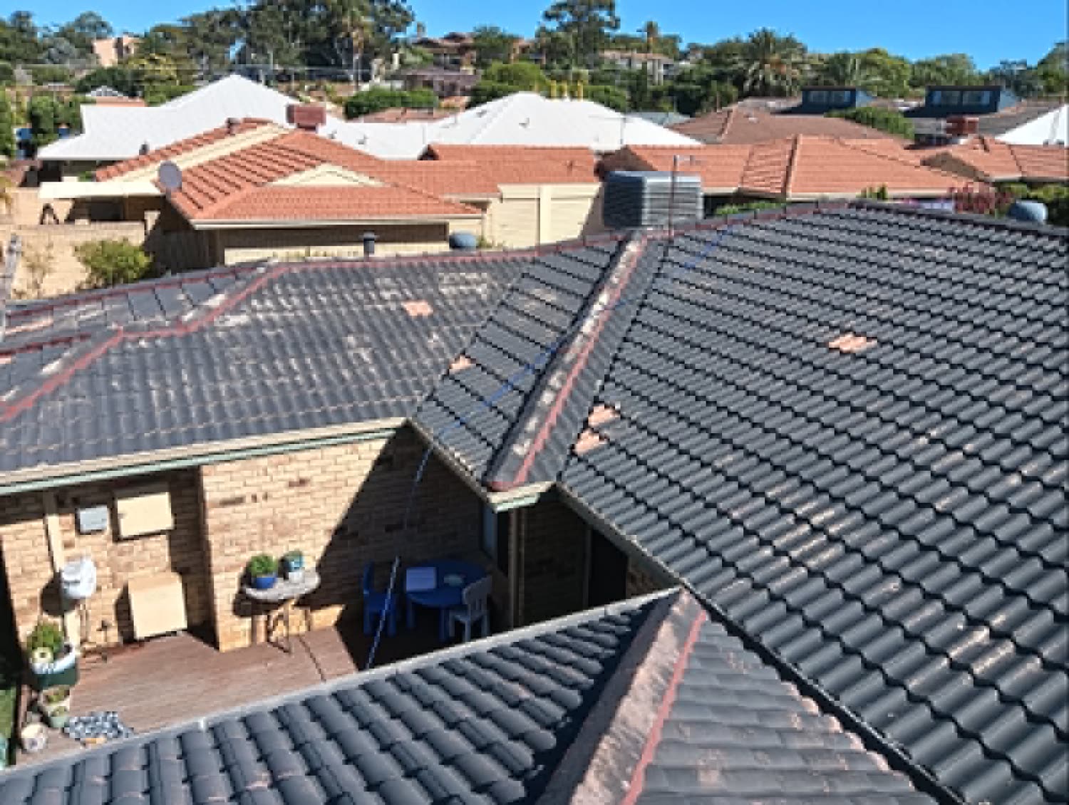 Before: the tile roof rebedded and repointed, the fresh mortar still showing along the ridges