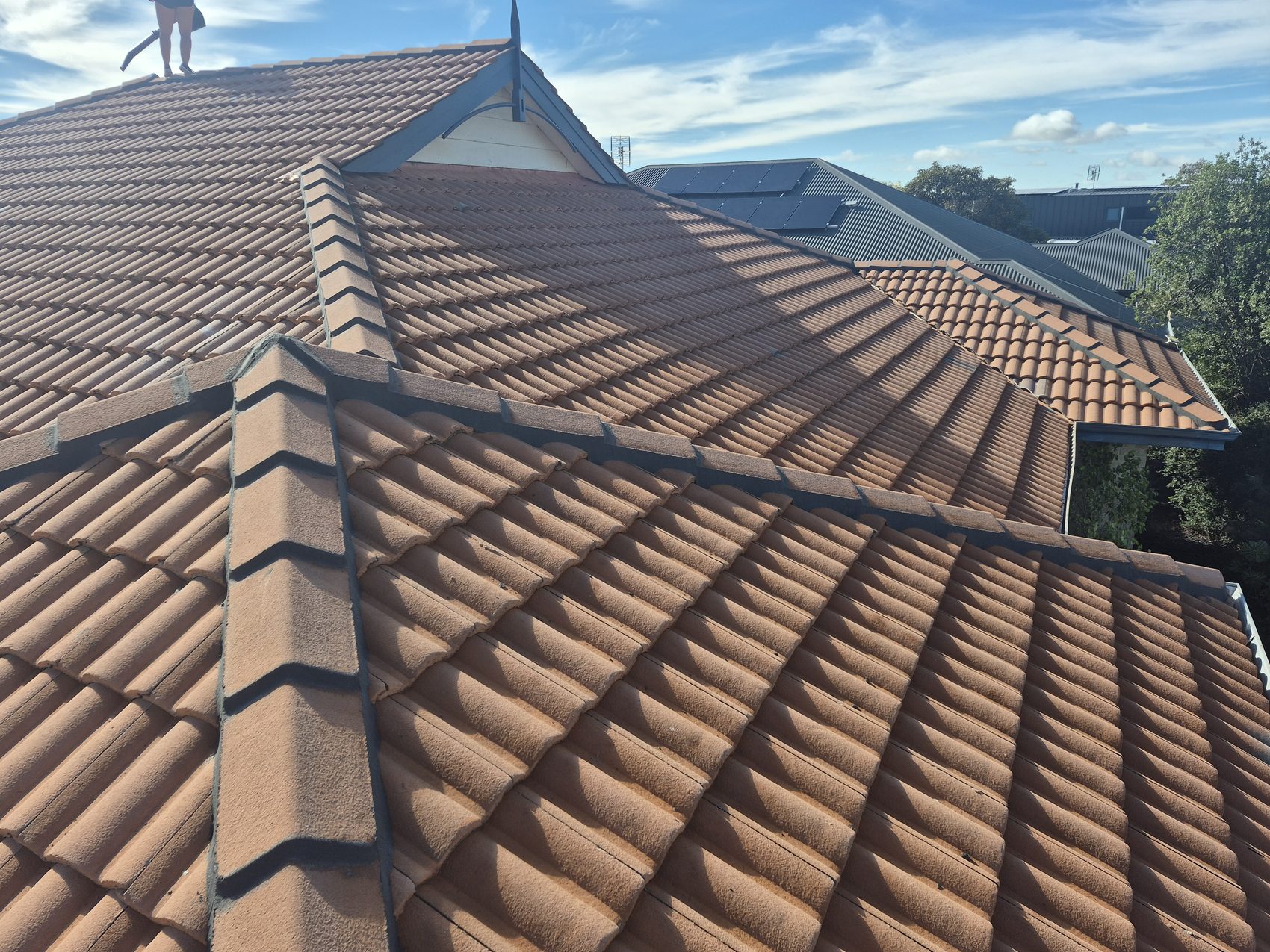 Before: a faded, weathered terracotta tile roof
