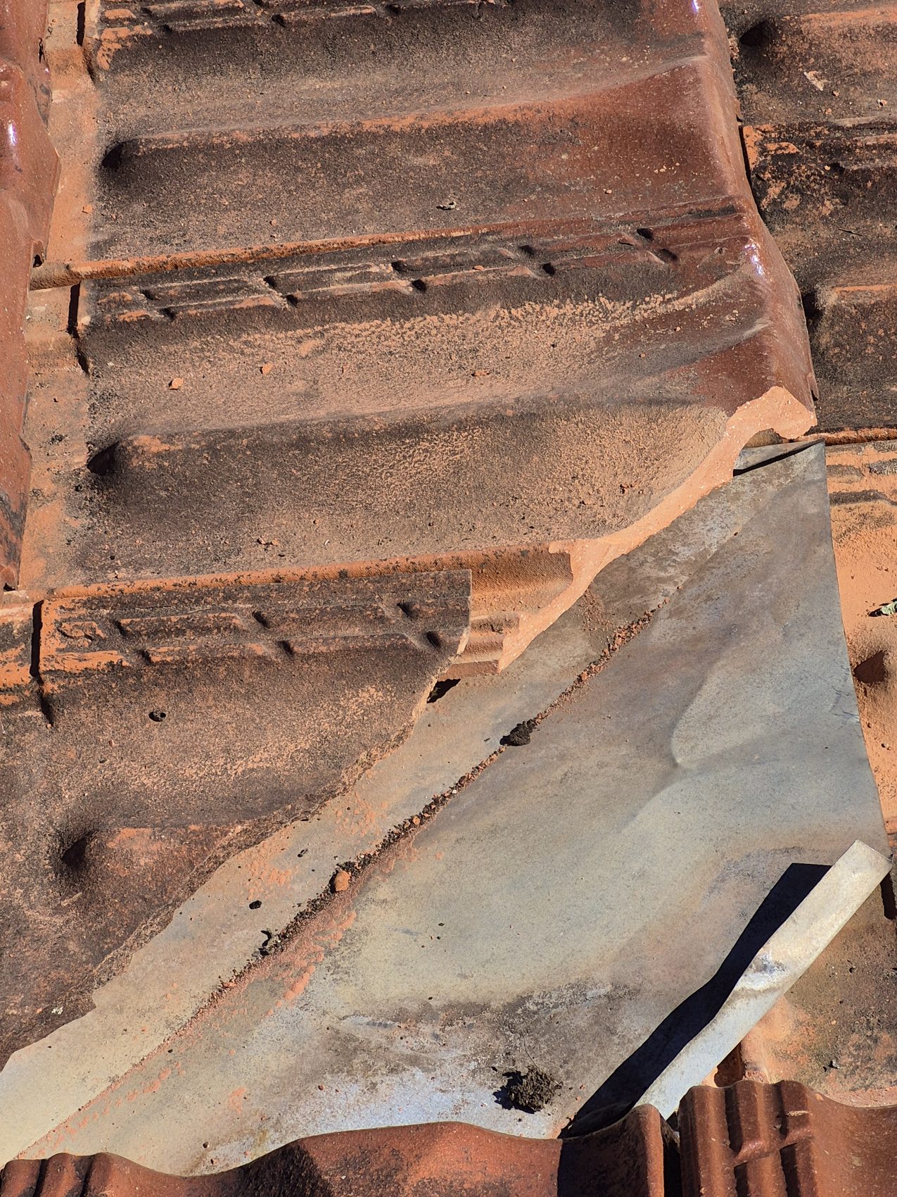 Cracked bedding under an old ridge cap, before repointing