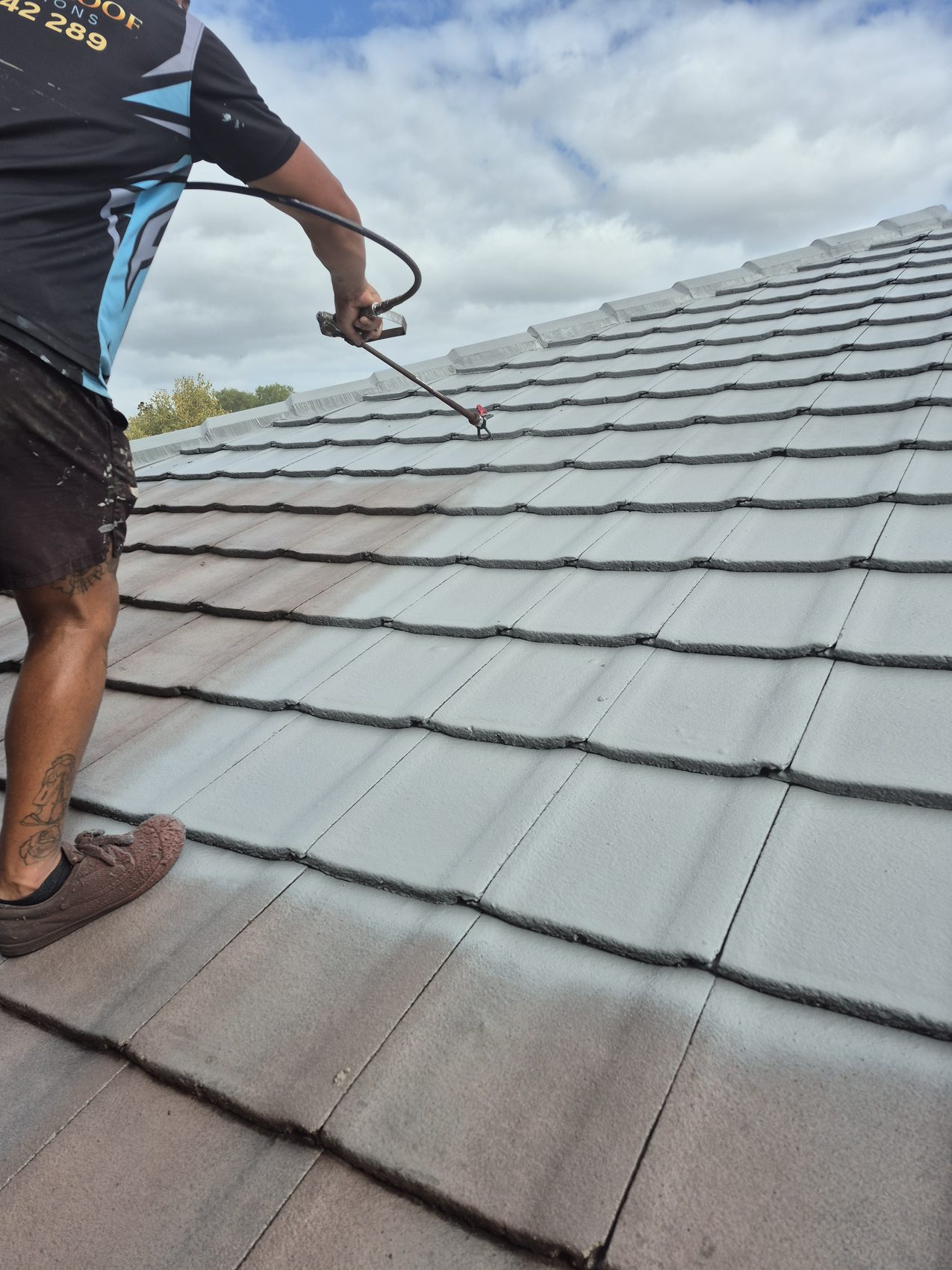 Applying a charcoal coating across a tile roof